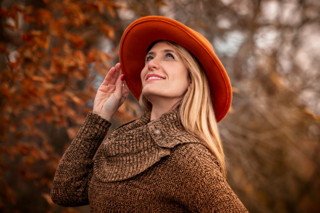 woman in an orange hat with clear skin during autumn